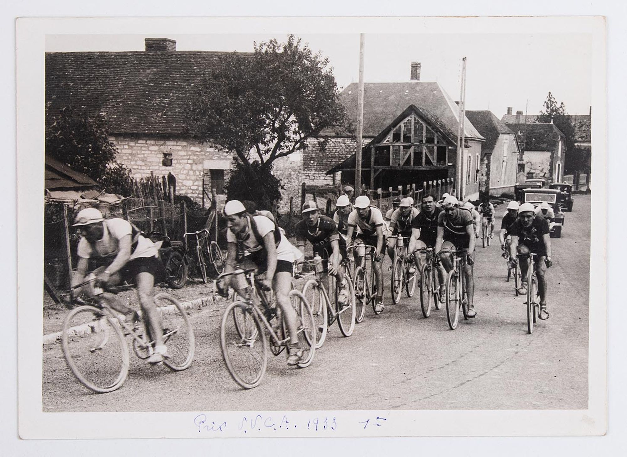 1933. Prix de l'Union Vélo Club de l'Aube (U.V.C.A). Le peloton passe dans un village. Lieu non identifié.
