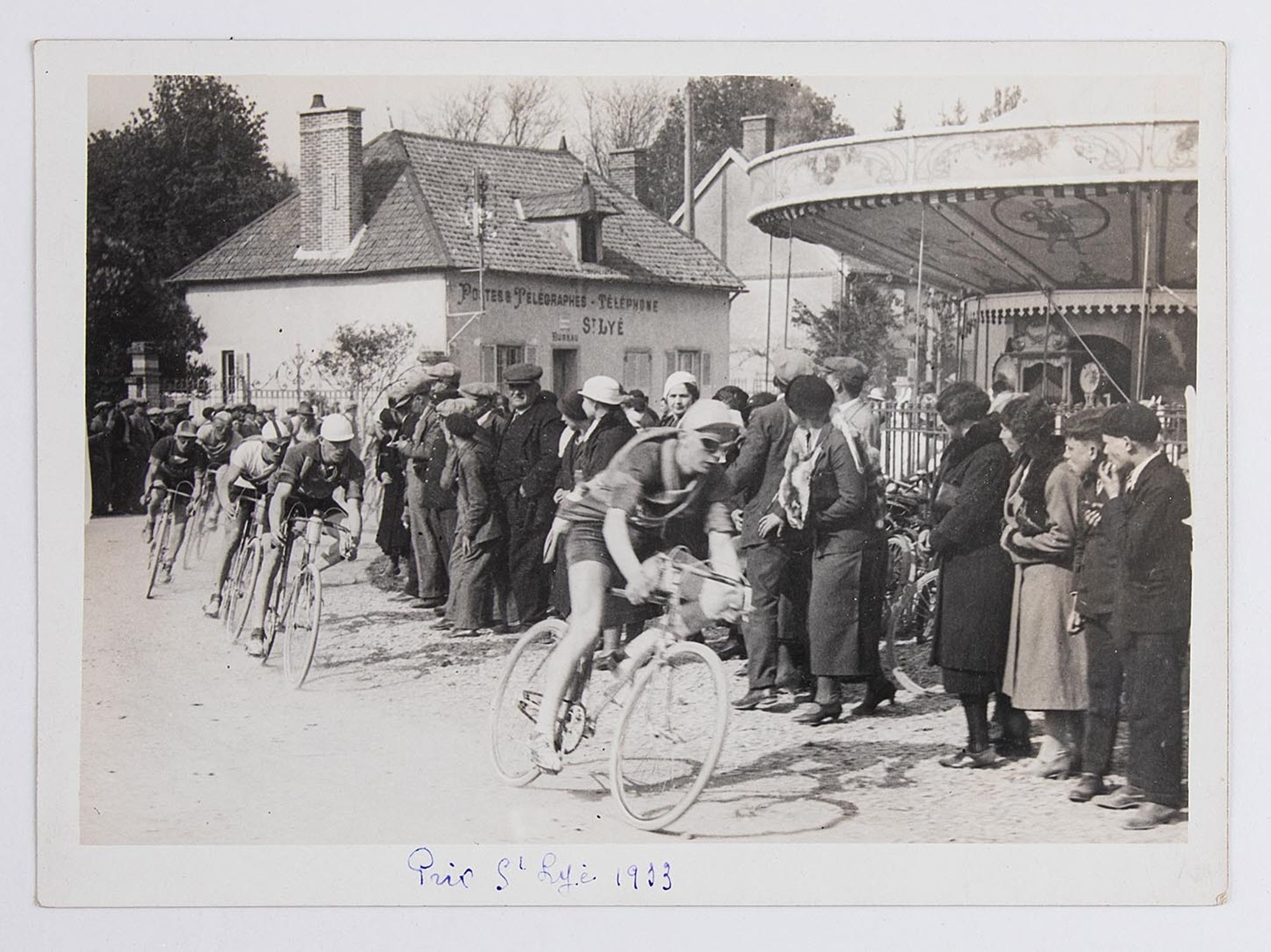 1933. Prix Saint-Lyé. Coureurs cyclistes et spectateurs sur la place de l'église de Saint-Lyé.