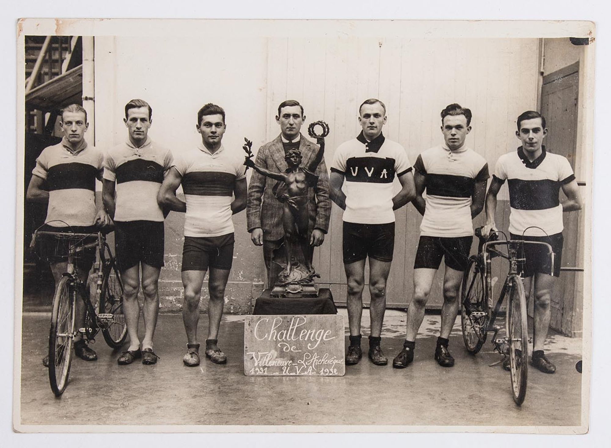 1932. Un groupe de coureurs cyclistes de l'Union Vélo Aube (U.V.A.) pose devant le trophée du challenge de Villeneuve-L'Archevêque (Yonne). Lieu à identifier.