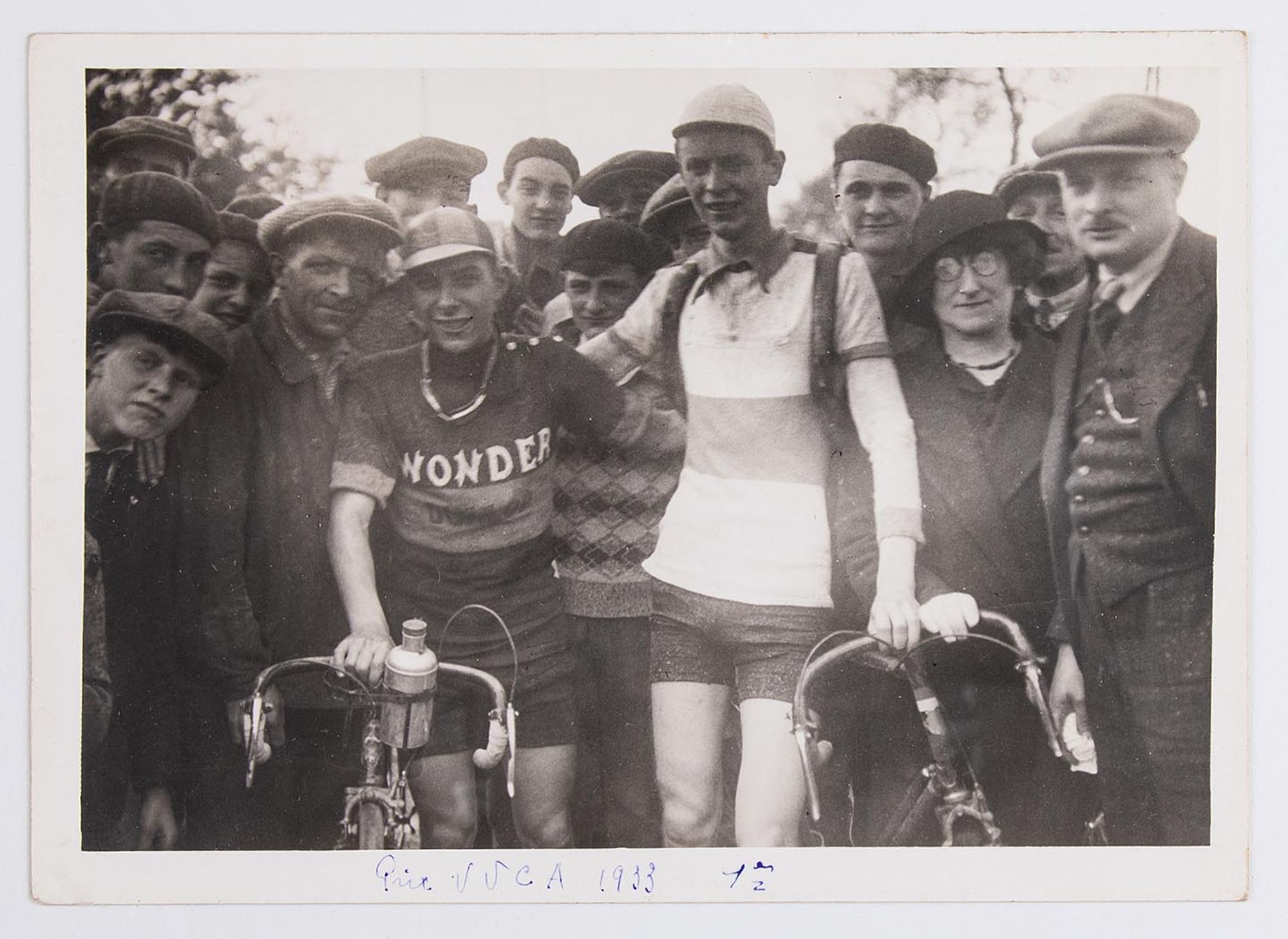 7 mai 1933. Prix de l'Union Vélo Club de l'Aube (U.V.C.A). Photographie de groupe. Hoffschir (maillot Wonder), premier, et Thivet, deuxième, posent au milieu des spectateurs, à Troyes. Lieu non identifié.