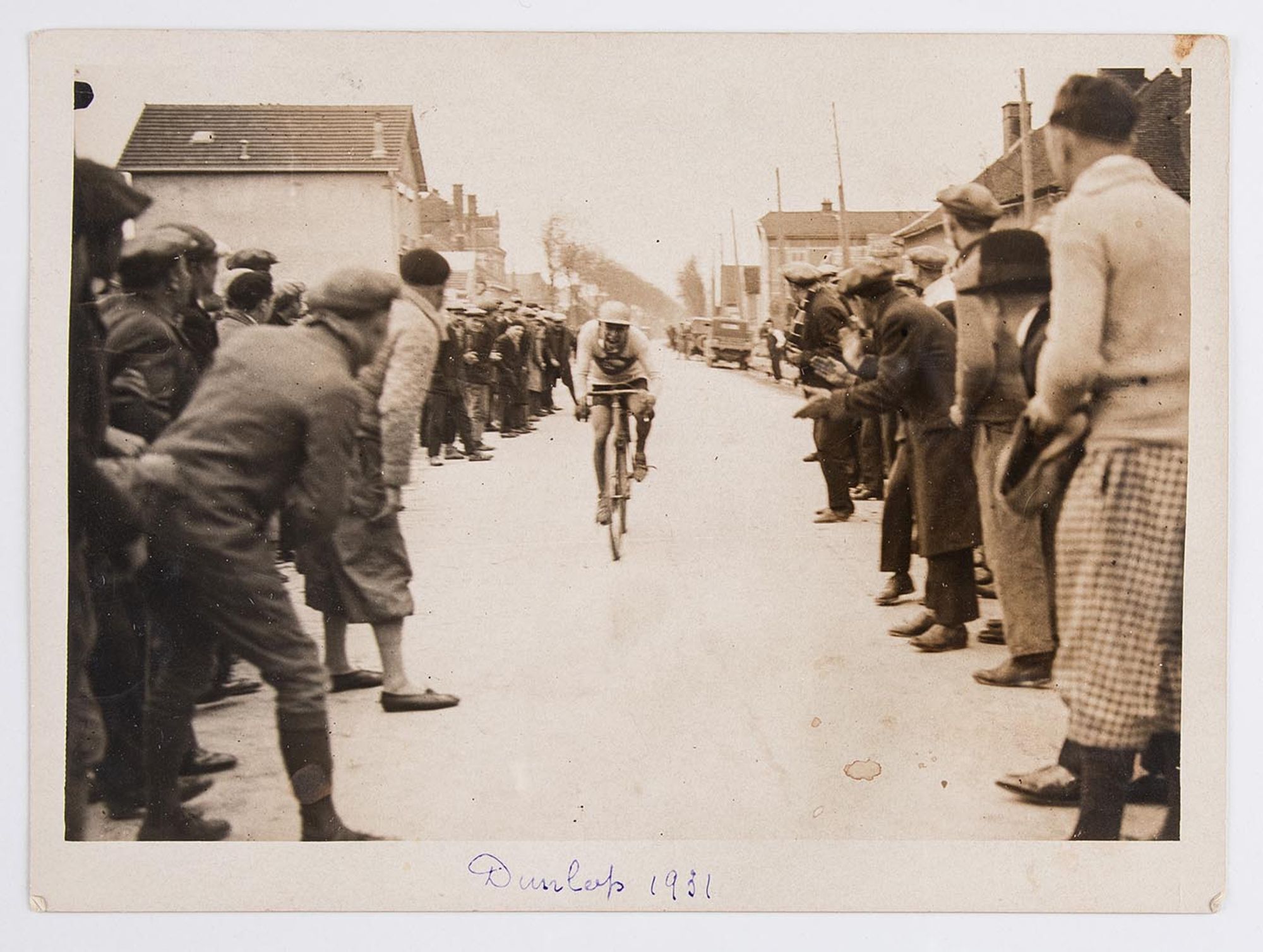 1931. Prix "Petit Pas" organisé par l'Union Vélo Club de l'Aube (U.V.C.A). Arrivée du premier coureur cycliste au milieu des spectateurs. Lieu à identifier.