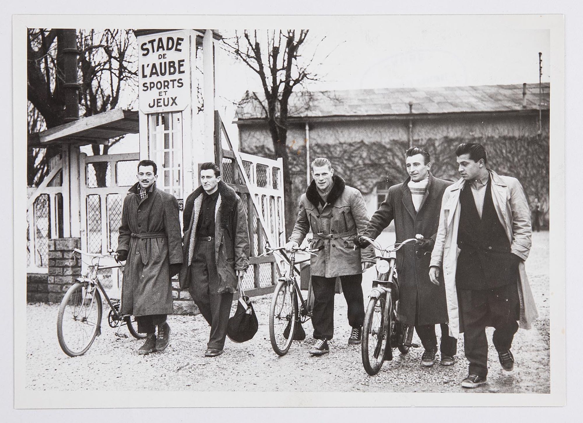 Photographie de groupe. Cinq joueurs de l'Association sportive Troyes-Sainte-Savine sortant du stade de l'Aube.