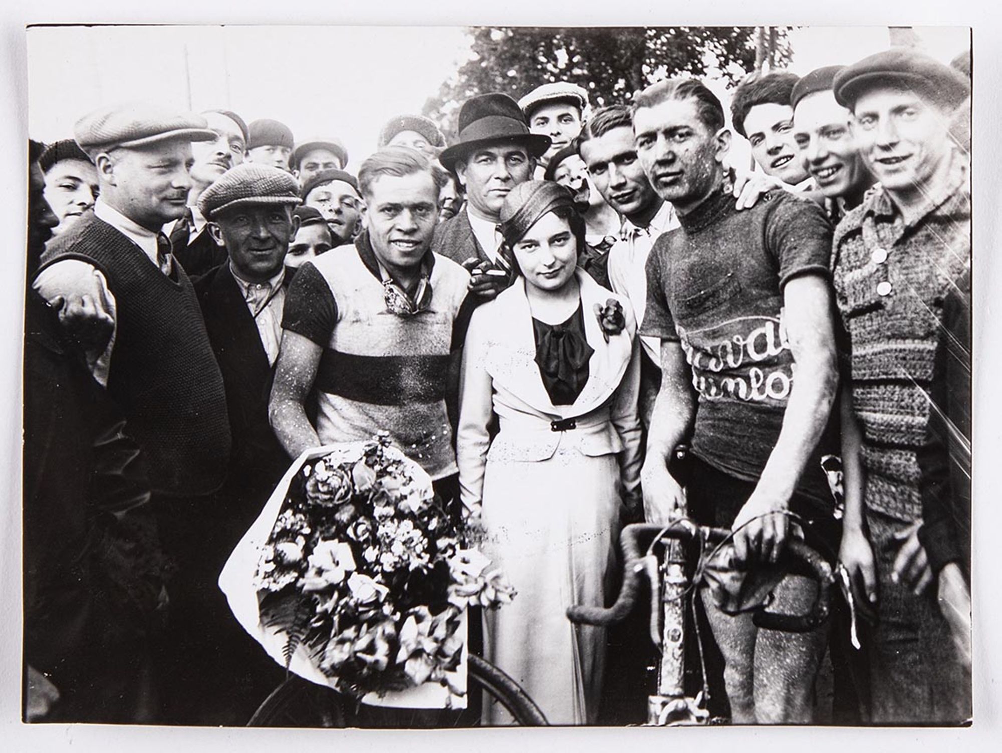 18 juin 1933. Grand prix Celor [huilerie industrielle de Saint-Ouen], organisé par le Vélo-club savinien. Photographie des vainqueurs : Bernard Masson, premier, et J. Krubs, deuxième, entourent une jeune fille et posent avec M. Guéniot, représentant des h