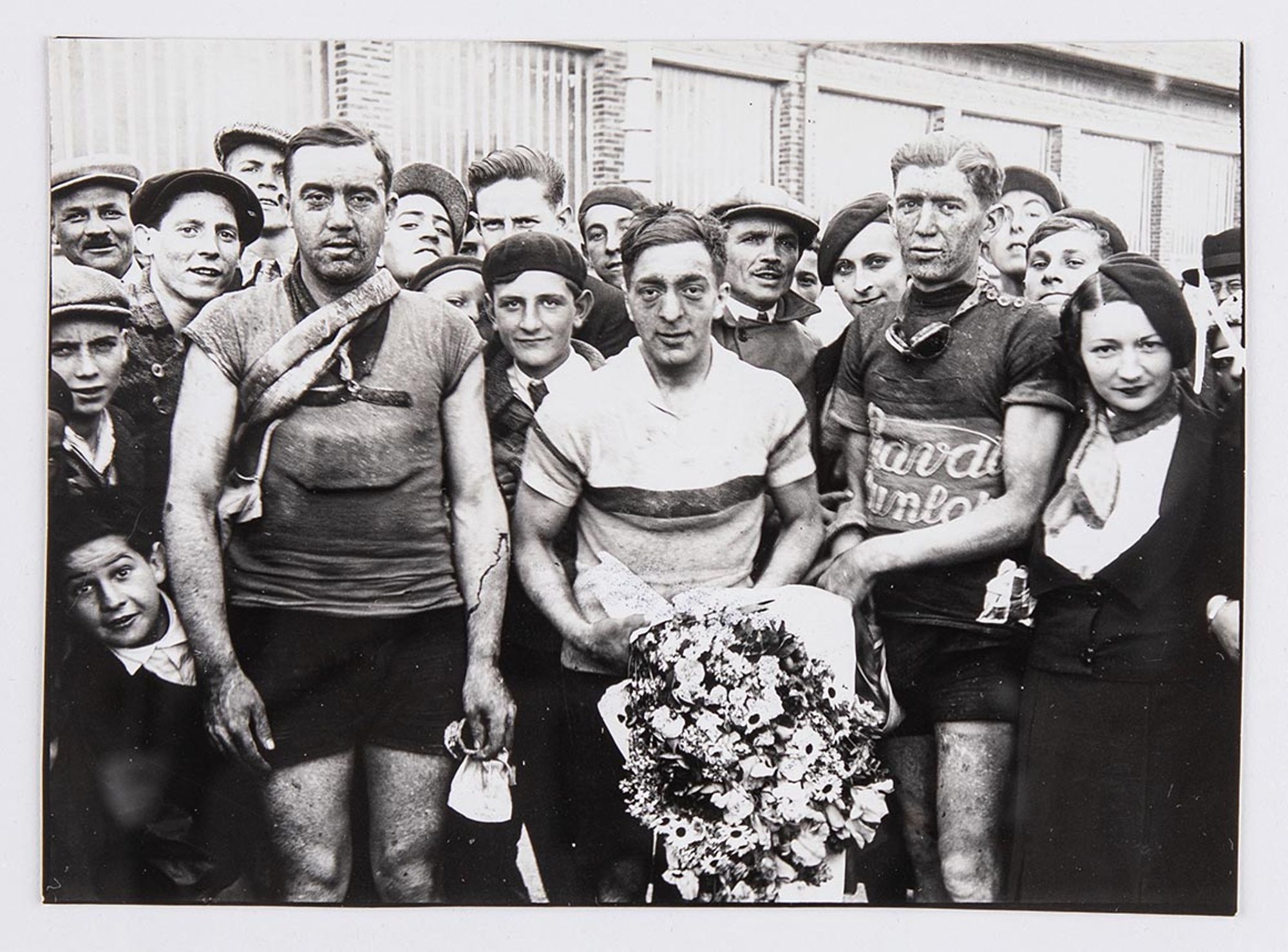 25 mai 1933. Prix Wonder organisé par l'Union Vélo Aube (U.V.A.). Photographie des vainqueurs à l'arrivée à Troyes, devant le café Pothier : Jack Cahen, au centre, premier, portant un bouquet de fleurs. René Lepeu, d'Auxerre, deuxième, à sa droite. J. Kru