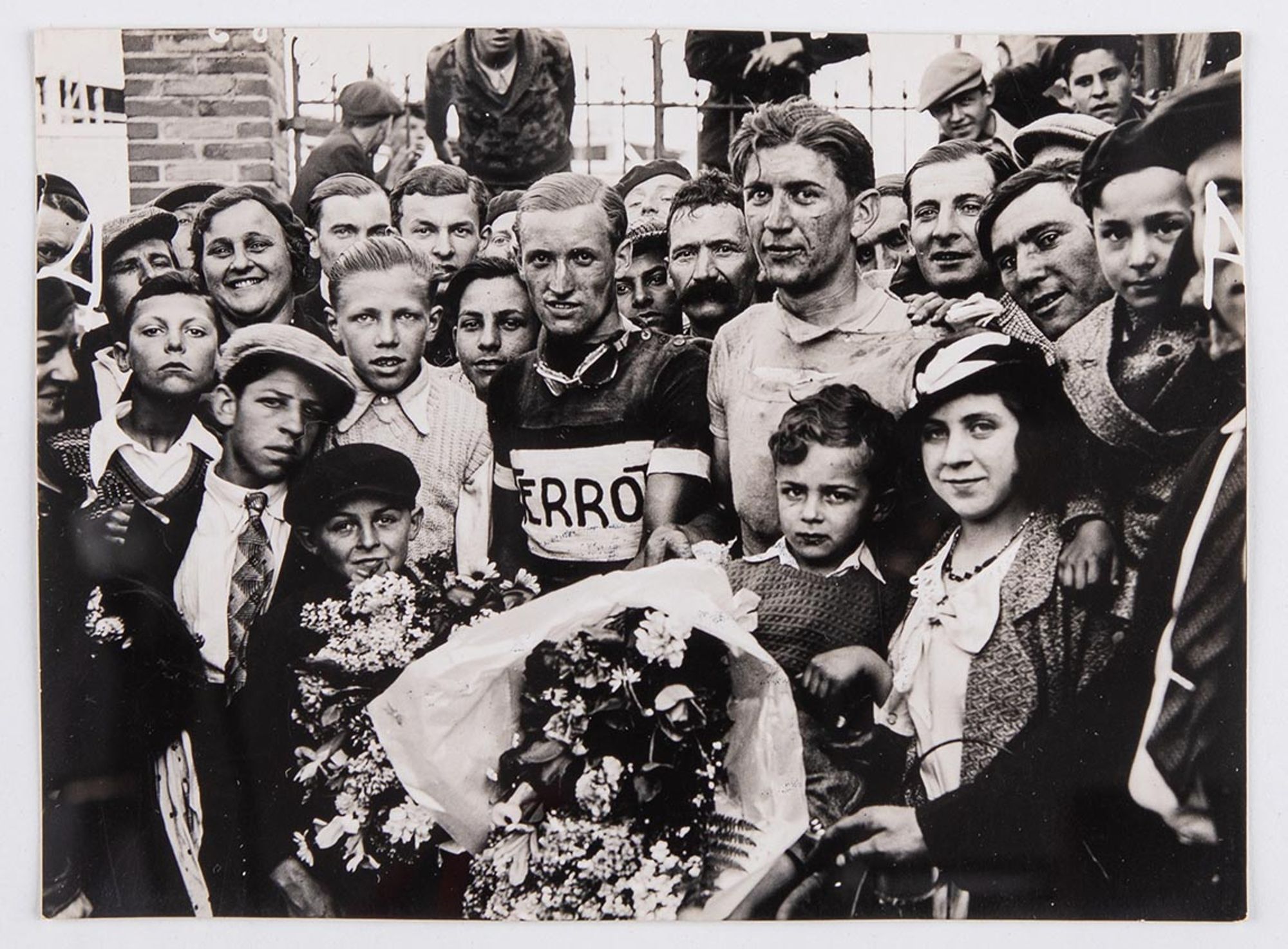 6 mai 1934. Prix Celor - huilerie industrielle de Saint-Ouen. Photographie des vainqueurs :  J. Krubs et Georges Royer posent au milieu des spectateurs. Lieu à identifier.