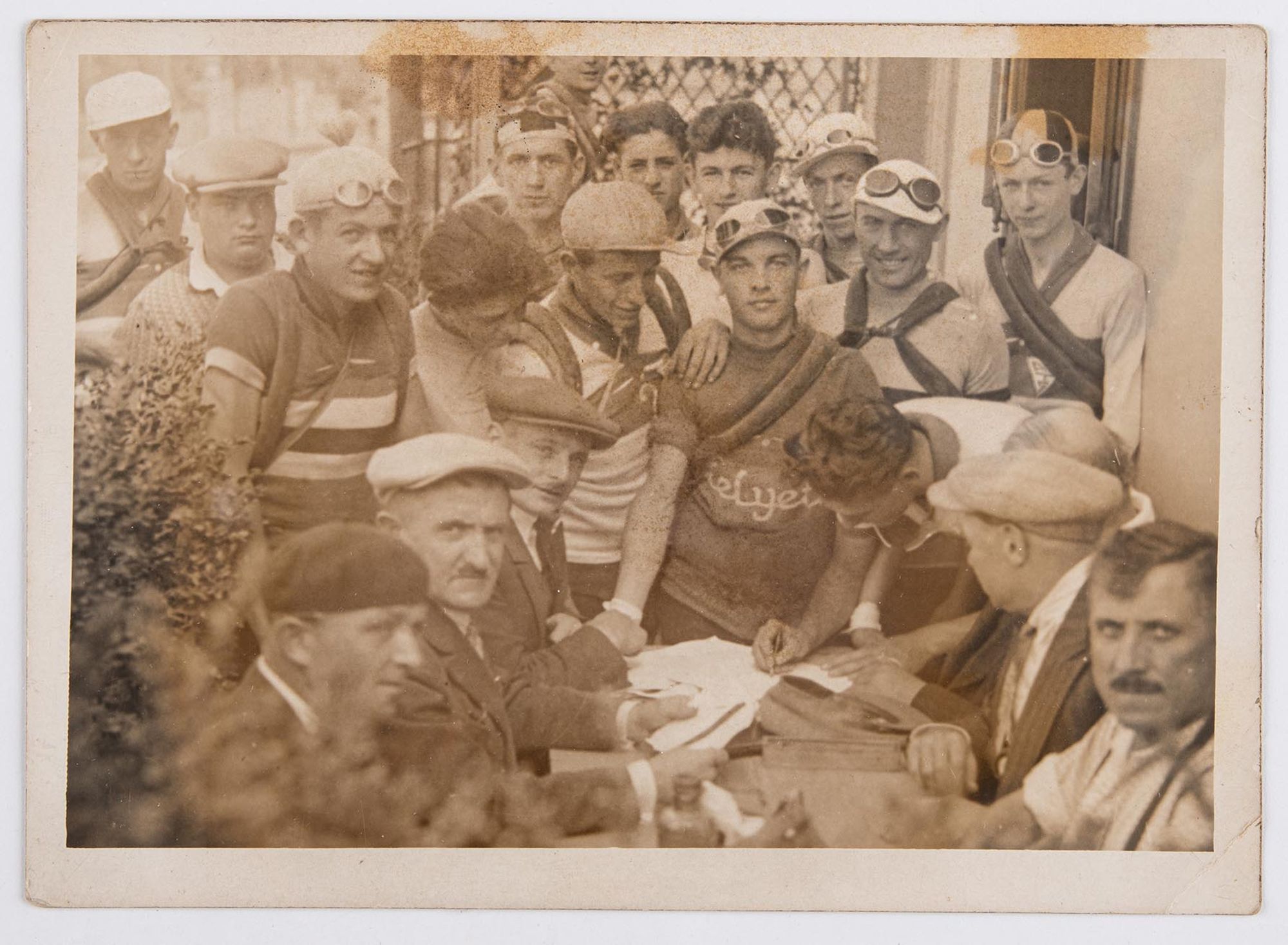 Portrait de groupe. Des coureurs cyclistes lors d'une signature. Course et lieu à identifier.